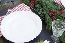 20 a modern tablescape with an evergreen and berry garland and striped napkins