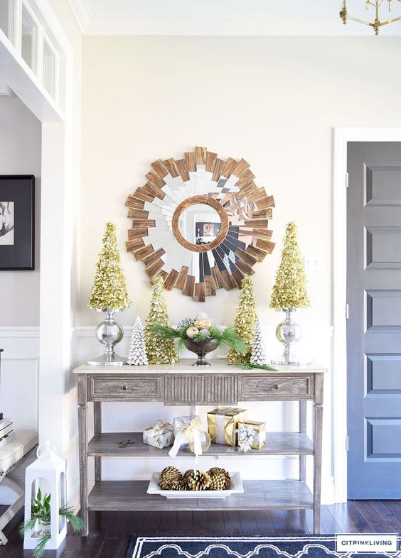 metallic trees and a bowl with evergreens and ornaments for a chic look