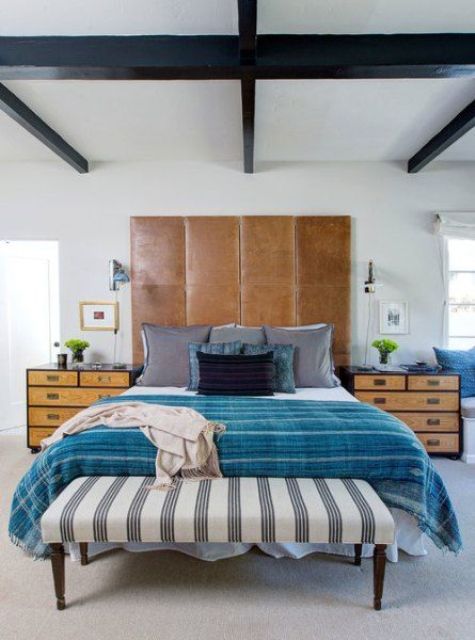 A large brown leather headboard is used as an eye catcher in this vivacious space