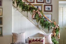 23 a lush evergreen garland with burlap bows and jingle bells for stairs decor