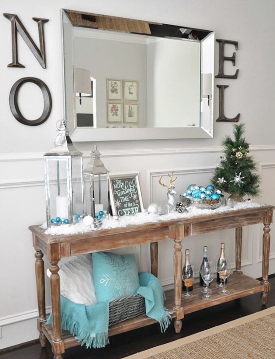 a vintage wooden console with faux snow, lanterns, a deer and turquoise touches
