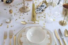 23 a white and gold tablescape with gold cutlery, goblets, candle holders and white blooms