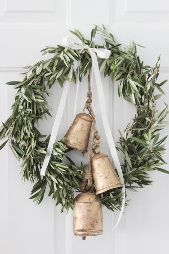 a greenery wreath with a ribbon bow and large vintage bells will make your space farmhouse like at once