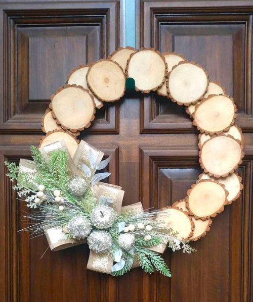 a wood slice Christmas wreath with silver frozen apples, faux greenery and berries