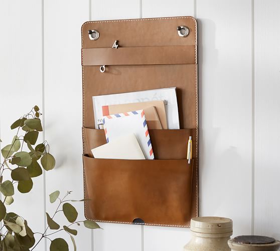 a brown leather wall storage piece for an entryway - put your keys and mail here