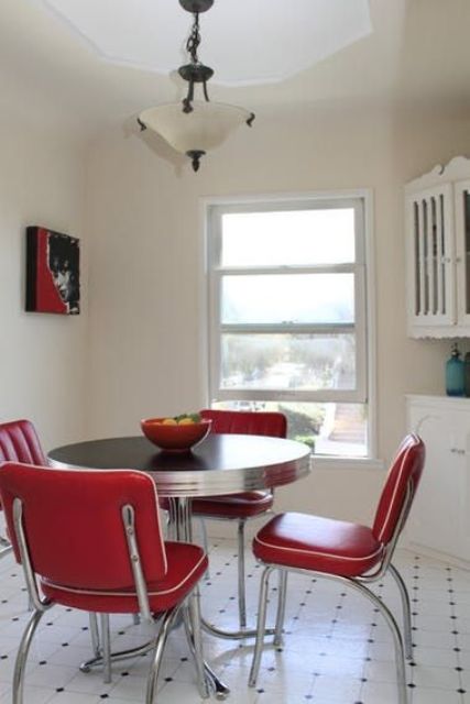 a retro dining zone with red chairs and a round table looks really retro-styled