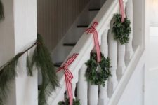 25 little boxwood wreaths with red and white striped ribbon for staircase decor