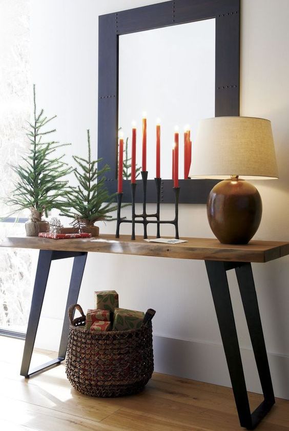 simple styling with evergreen trees, red candles and a basket with gifts