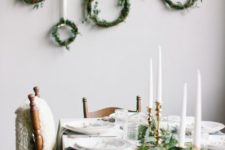 26 some greenery on the table and greenery wreaths hanging on the wall and gold candle holders for simple and cute decor