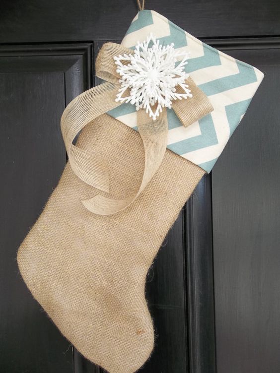 A burlap stocking with chevron decor, a snowflake and a burlap bow for front door or mantel decor