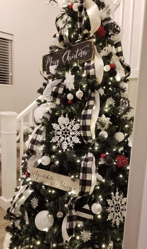 a beautiful Christmas tree decorated with black and white baubles and red yarn ornaments, buffalo check ribbons, snowflakes and stars plus signs