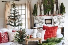 a bold farmhouse Christmas living room with a tree, mini trees, a wreath, colorful ornaments and wooden furniture
