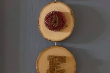 a creative Christmas decoration of tree slices and colorful string art letters is a cool idea instead of a wreath