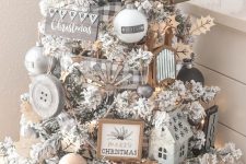 a flocked Christmas tree with wooden ornaments, buffalo check ribbon, lights and leaves for a farmhouse space
