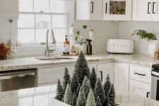 a modern farmhouse Christmas centerpiece of a tray with mini bottle brush Christmas trees is a cool idea
