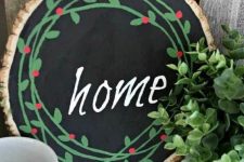 a painted Christmas sign with chalkboard paint, bright green and red decor and a chalk word for a cozy rustic feel