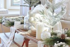 farmhouse Christmas decor with a sleigh, evergreens, ornaments and candles is a creative and cool idea