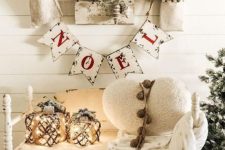 white farmhouse Christmas decor with bunting, candle lanterns, a white heart pillow and some white branches