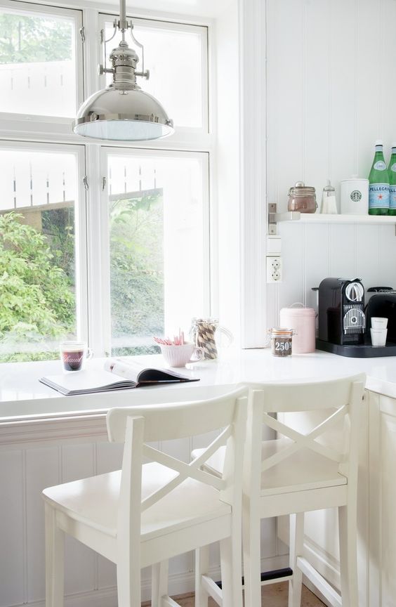 a kitchen counter is continued into a windowsill and is used as a breakfast bar