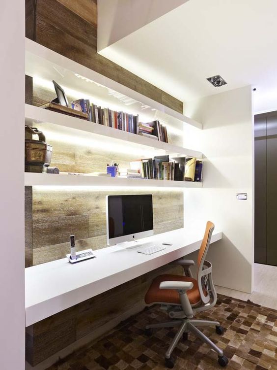 An ultra modern workspace with lit up floating shelves and a desk for comfy working