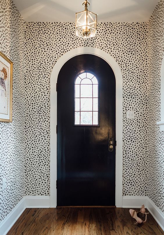 sophisticated mid-century modern entryway with Dolmatin print wallpaper and gilded touches