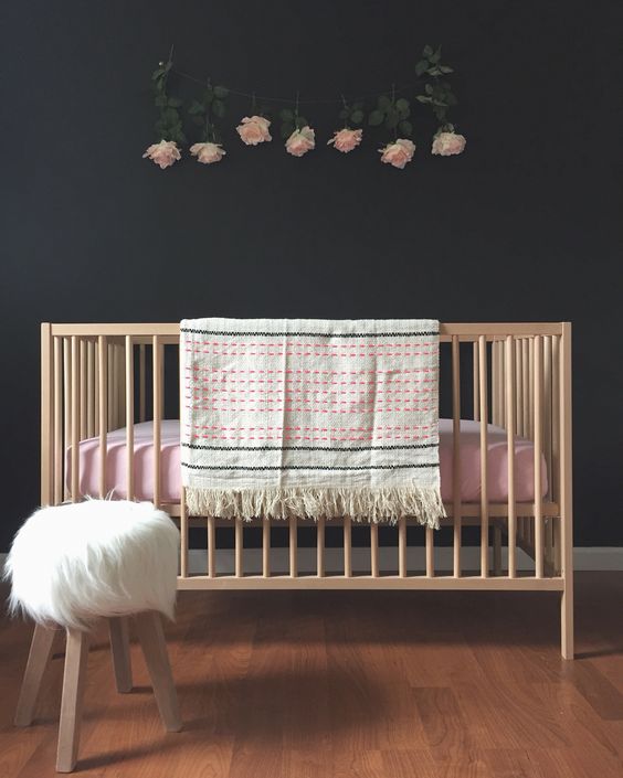 IKEA Sniglar crib in a black nursery with blush and pink accent - ideal for a girl's space