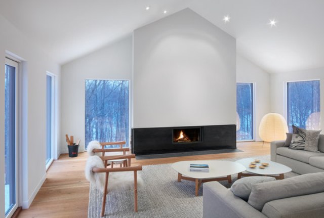 The living zone is done with many windows to enjoy the views, a separate fireplace wall as a centerpiece