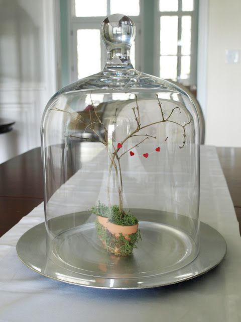 a cute centerpiece of two planters with moss, branches and a little red heart banner