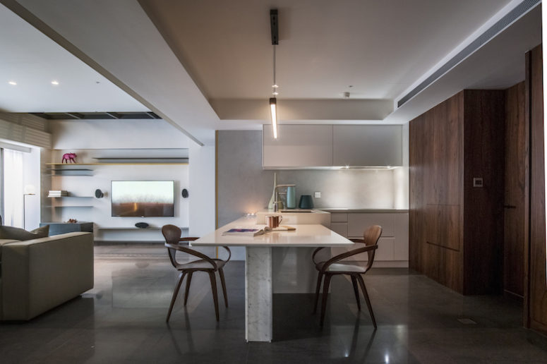 A dining table is attached to the kitchen island and is perfectly integrated into the kitchen zone