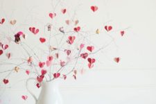 05 a modern Valentine’s Day centerpiece of a white jug and pink, blush and gold hearts on branches