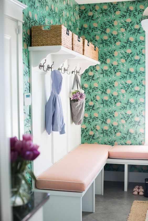 bold green wallpaper with a floral print and matching cushions on the benches