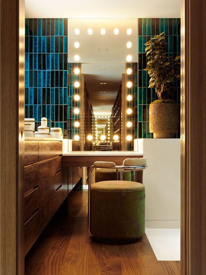 One of the bathrooms includes a makeup nook with a lit-up mirror and a comfy upholstered chair