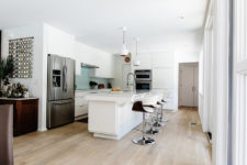06 The kitchen with white cabinets and a large kitchen island is only visually separated from the dining room