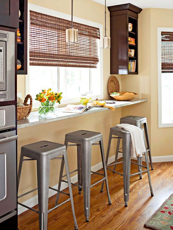 a windowsill breakfast bar with industrial stools and some storage shelves on both sides