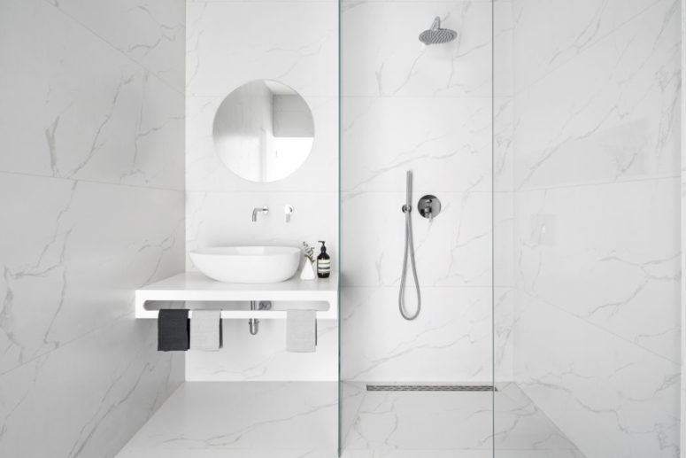 The bathroom is completely covered with white marble for a chic modern look