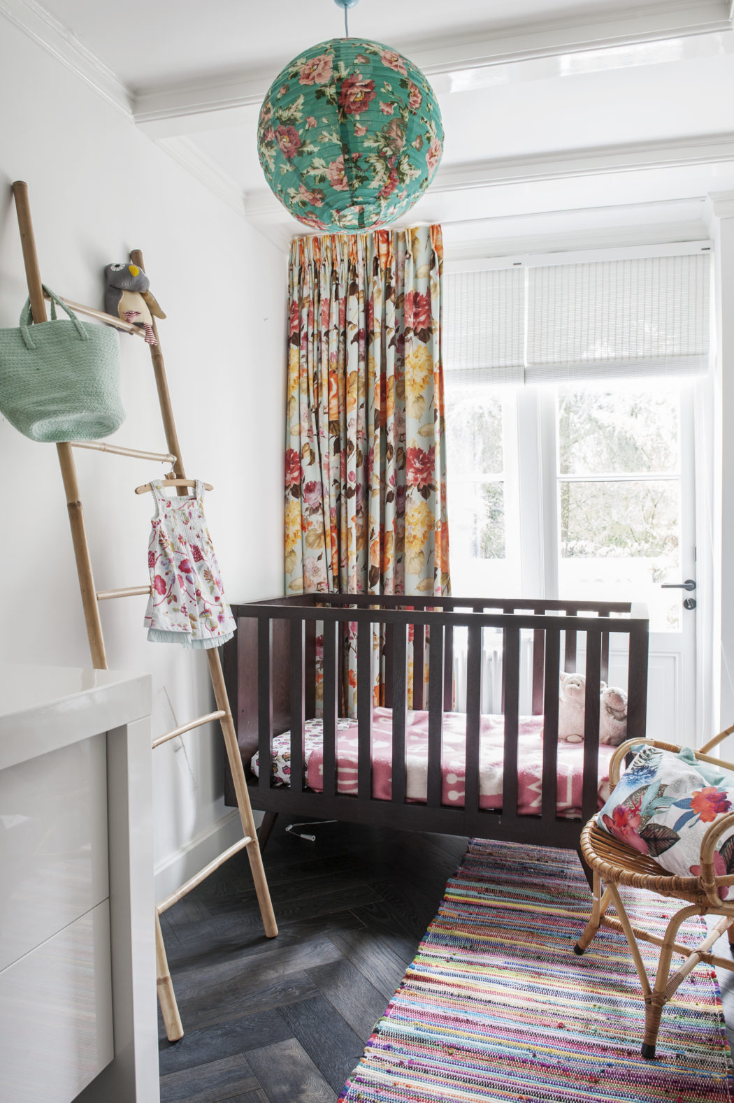 The kid's space is done with floral textiles, a striped rug and looks very lively and colorful   exactly what a small girl needs