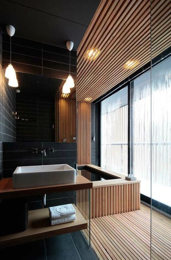 a contemporary bathroom with a spa feel, which is achieved with wood and a wood clad bathtub
