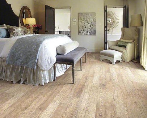 a vintage-styled bedroom with an elegant feel and laminate flooring, which looks like wood