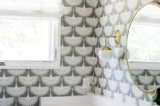 08 The bathroom is decorated with statement wallpaper and bold brass touches