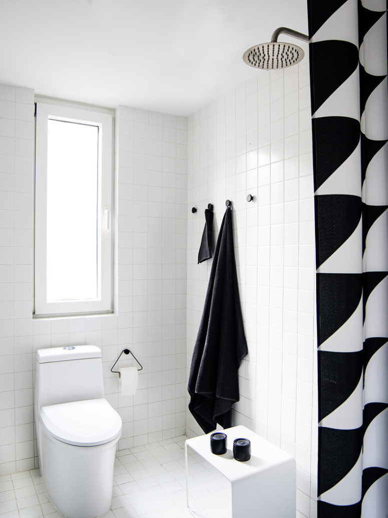 The bathroom is done in black and white, its decor is simple and laconic