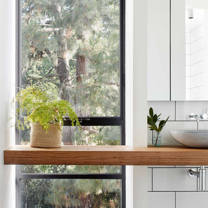 The sink stand is a floating one, there's one more window and potted greenery adds to the space