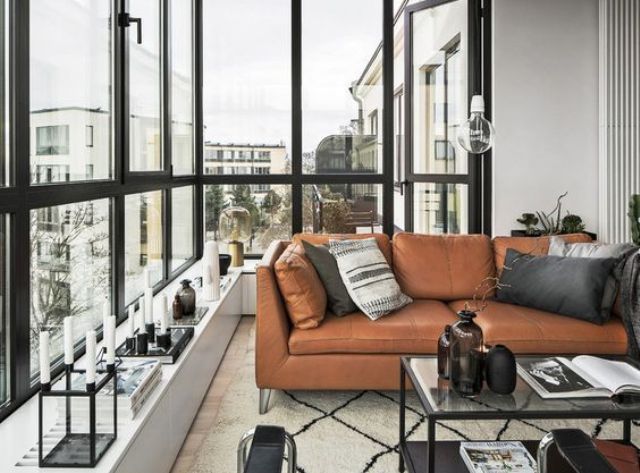 a gorgeous Scandinavian monochrome space is warmed up with a tan leather Stockholm sofa
