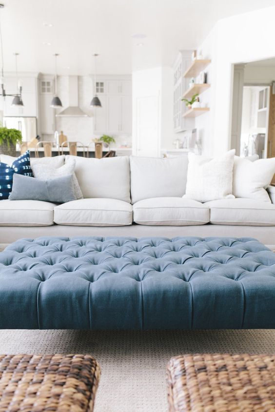 a large tufted blue ottoman hints that it's a beach space