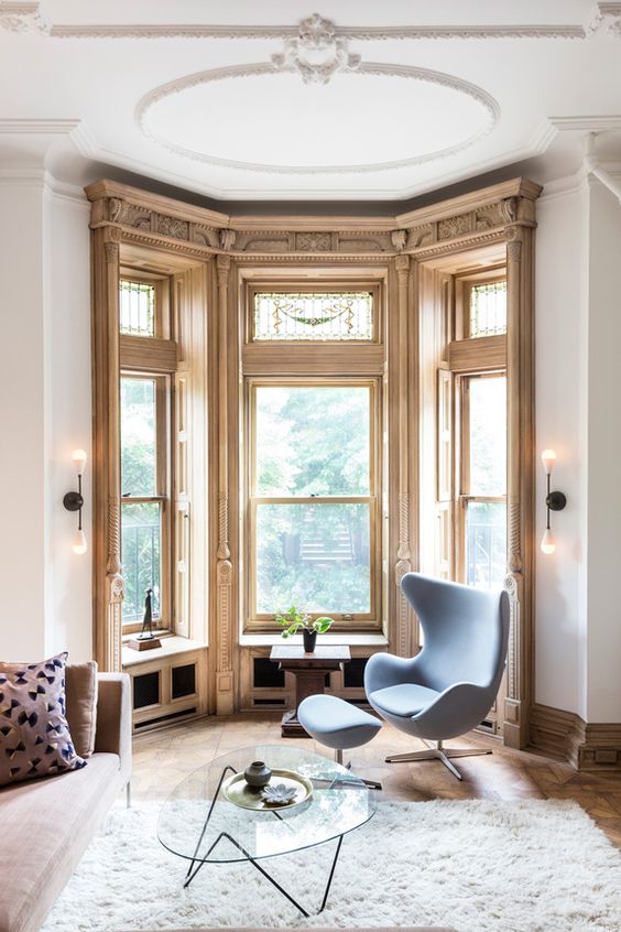 an awkward corner turned into a gorgeous reading space with large windows and an egg chair