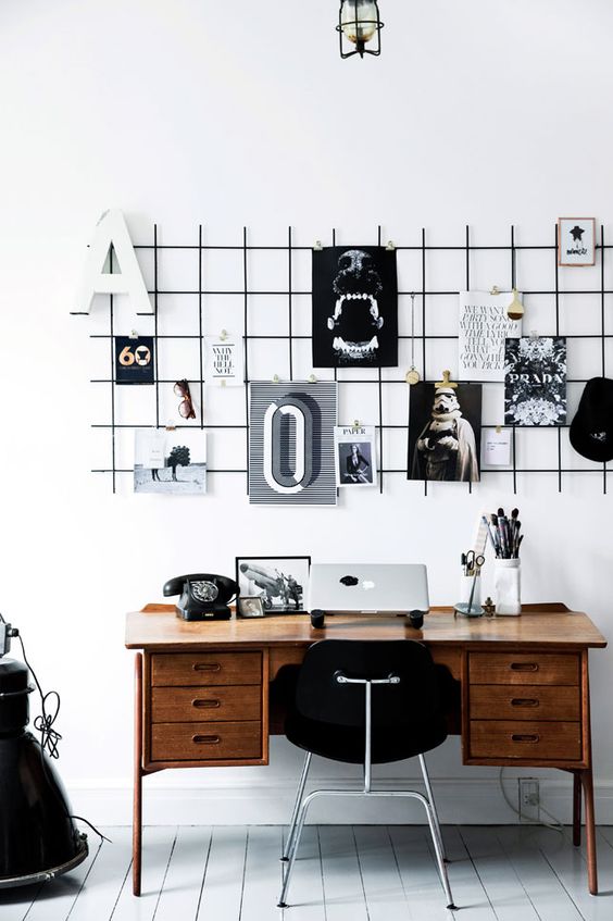 a black grid hung over the desk is a great piece to use as a pinboard