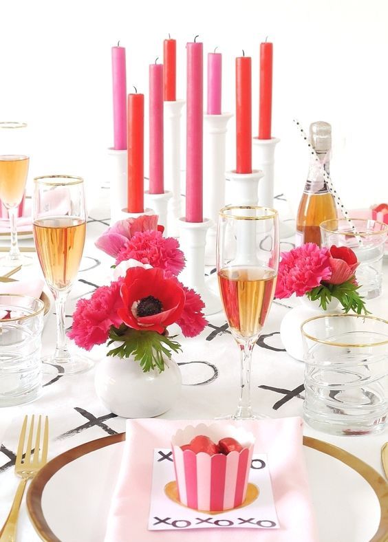 a modern tablescape with pink and red touches, blooms and candles