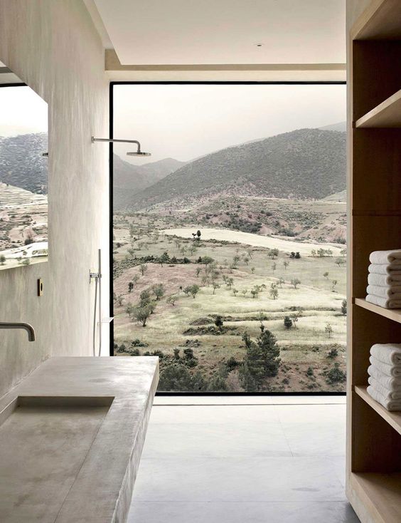 A minimalist bathroom with a glazed wall that offers stunning views of the moors