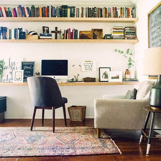 a cozy modern home office with floating shelves and a desk that go along the whole wall