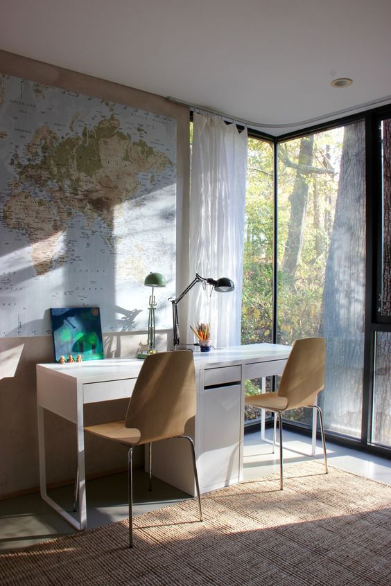 a modern double workspace or study space with Micke desks and wooden chairs next to a glazed wall