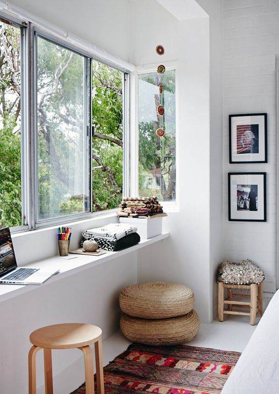 a window with a narrow windowsill used as a desk and for storage